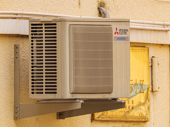 An outdoor air conditioning unit mounted beside a wall