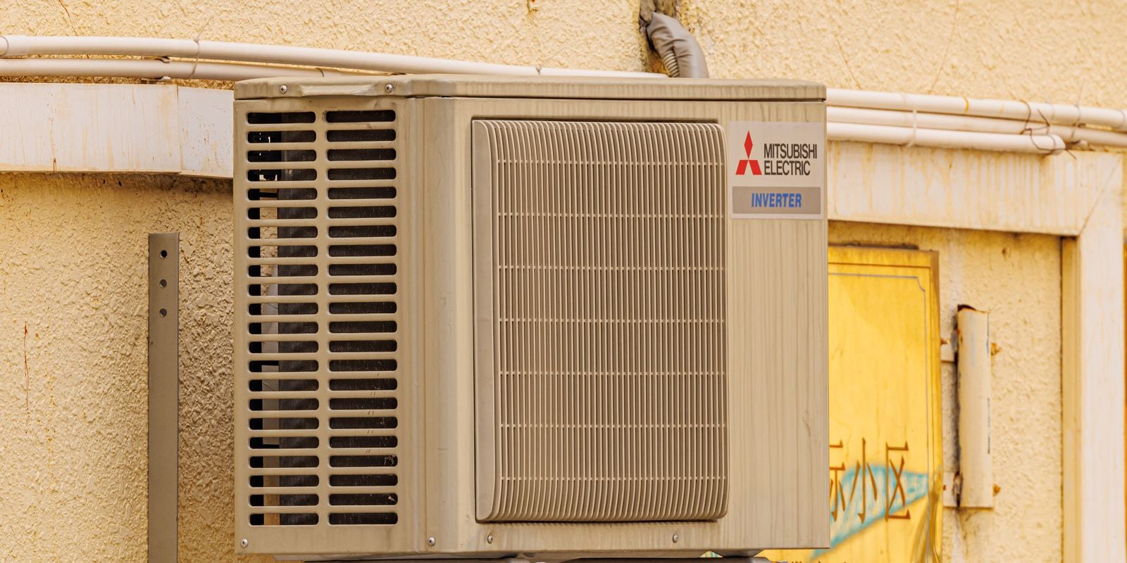 An outdoor air conditioning unit mounted beside a wall