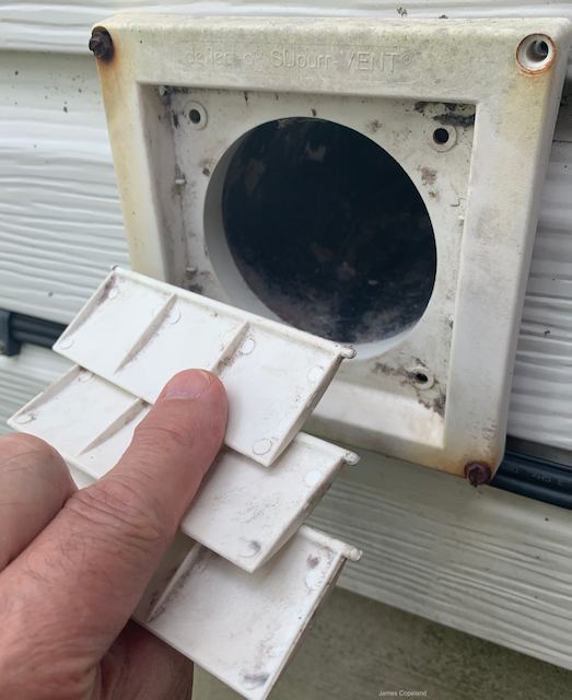 An outdoor dryer vent hood with three plastic flaps