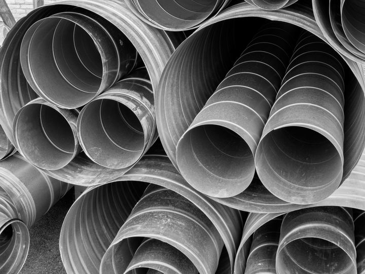 A stack of round galvanized steel air duct pipes