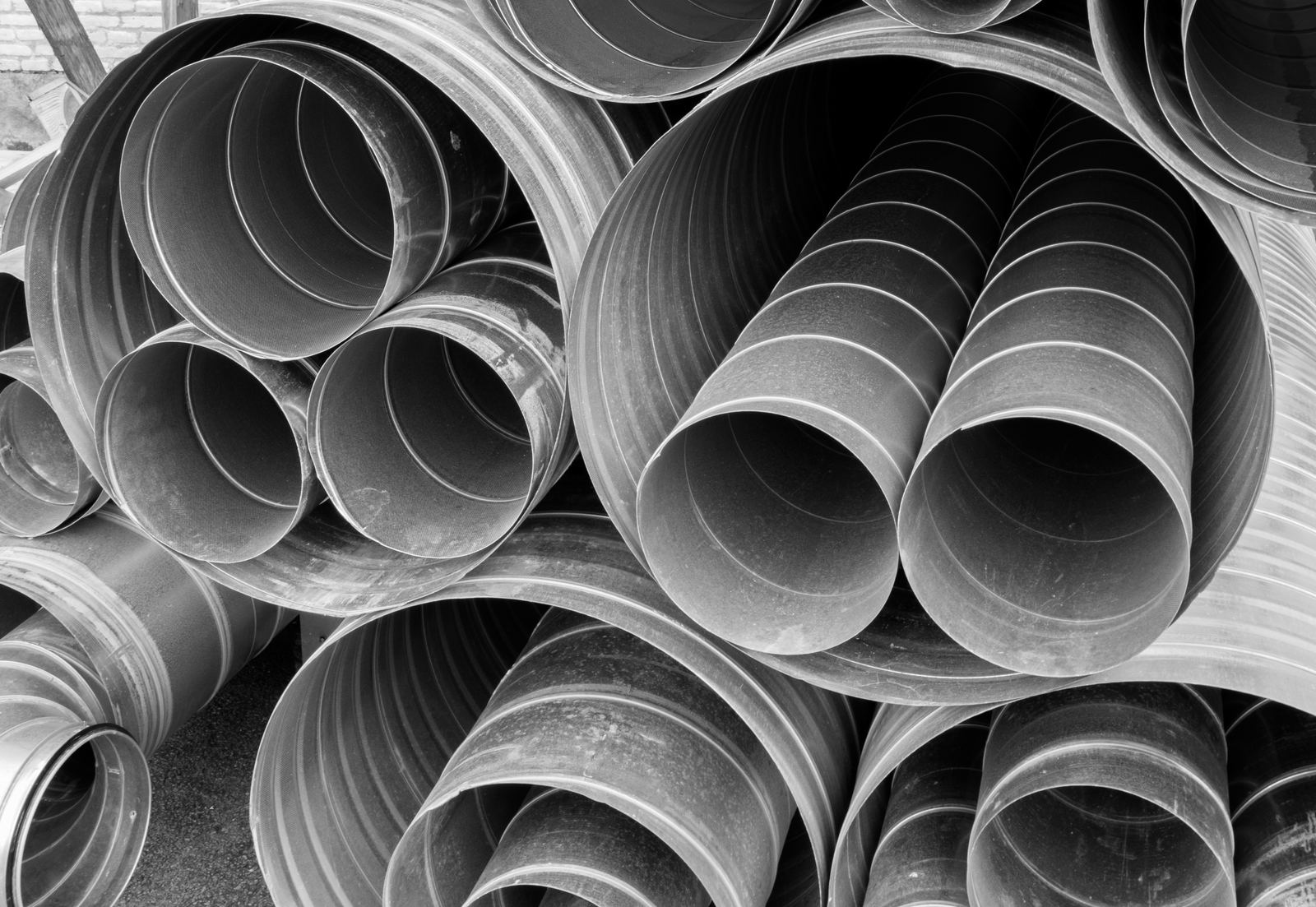 A stack of round galvanized steel air duct pipes