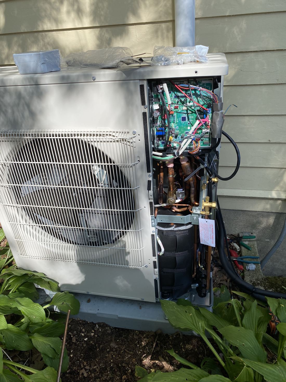 The inside of an outdoor heat pump unit with its cover removed