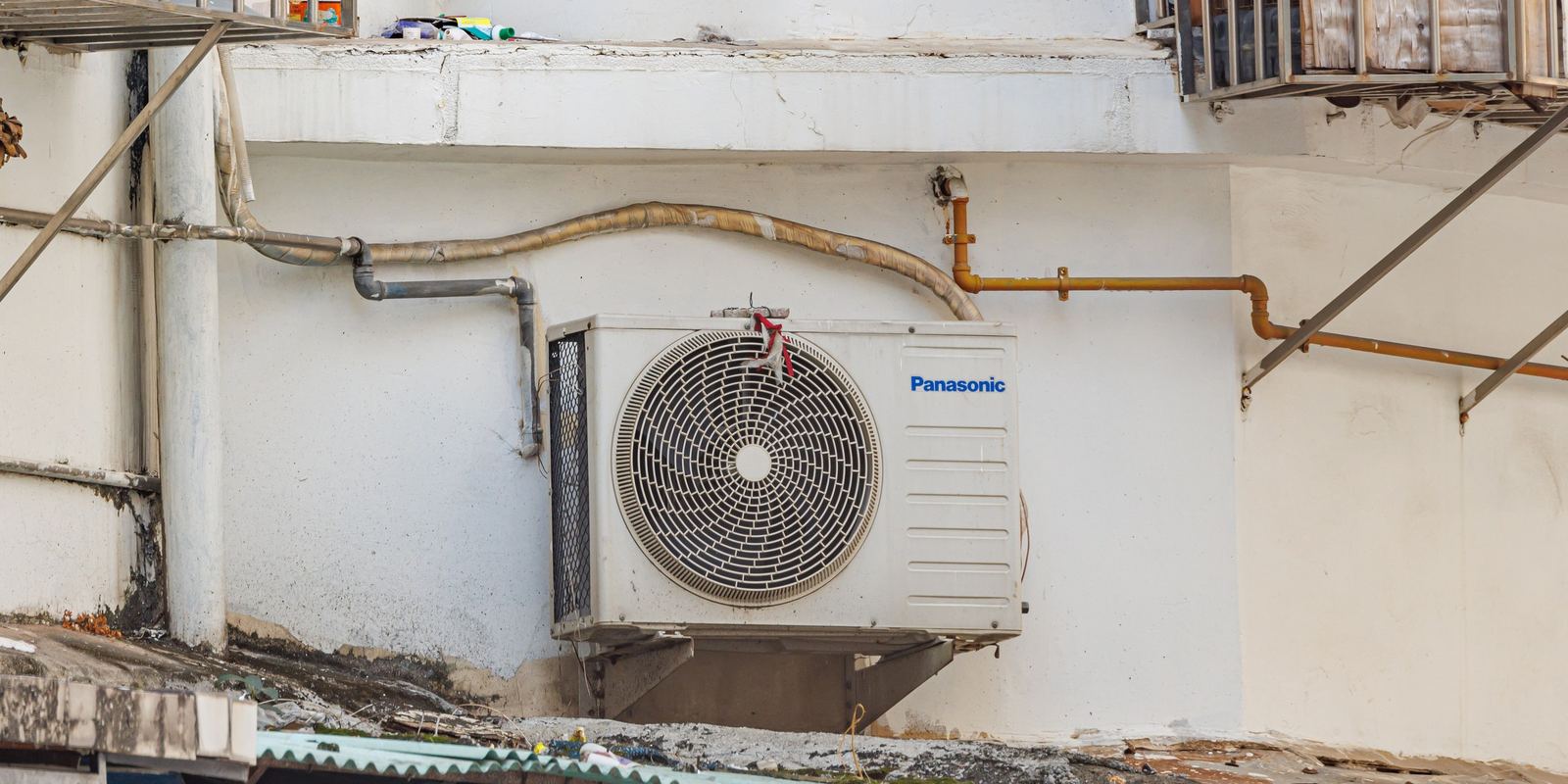 An outdoor air conditioner condenser unit beside a building