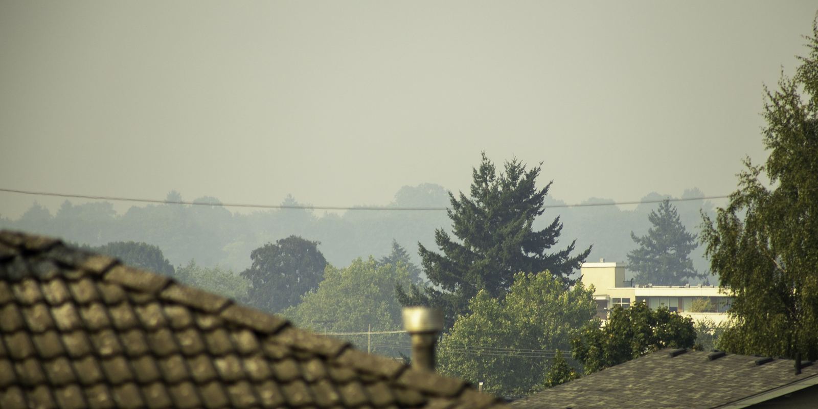 A city skyline hidden behind orange wildfire smoke haze